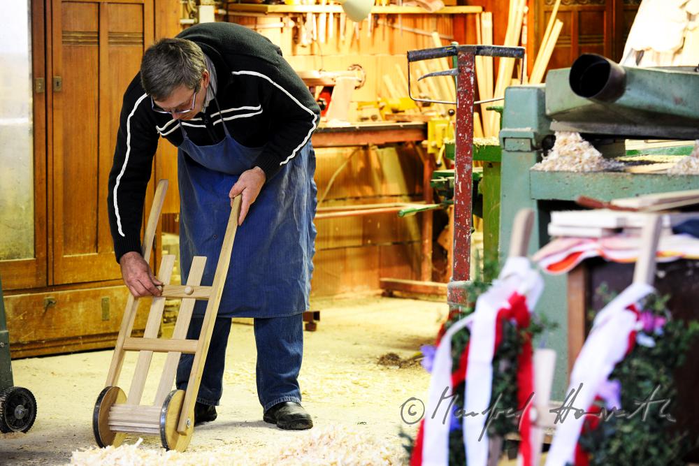 Hobbytischler in seiner Werkstatt beim Bauen einer Osterratsche