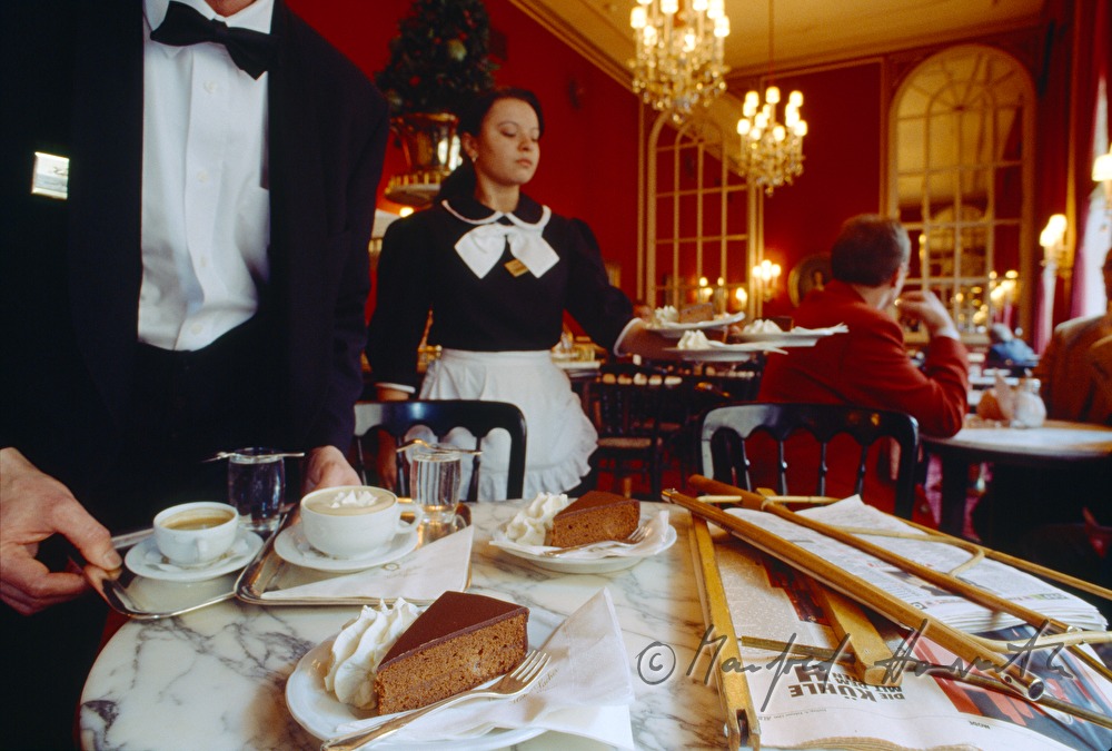 Ober serviert Sachertorte und Melange