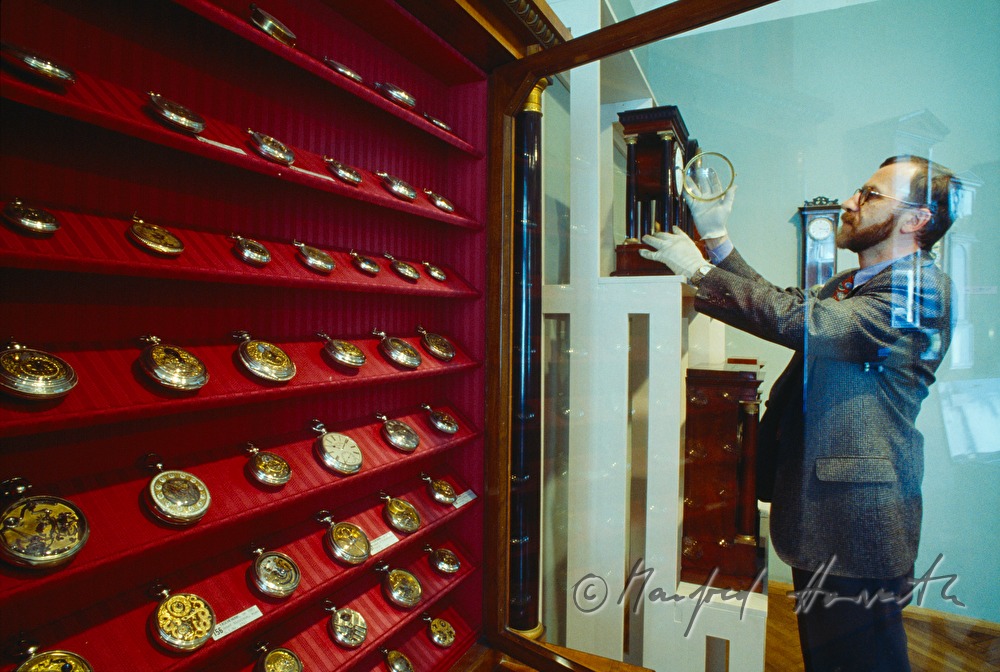 Direktor Rupert Kerschbaum öffnet eine Wanduhr