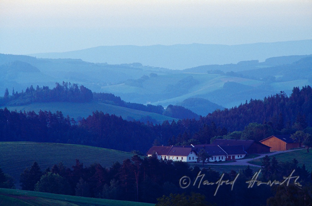 Bauernhof in hügeliger Landschaft