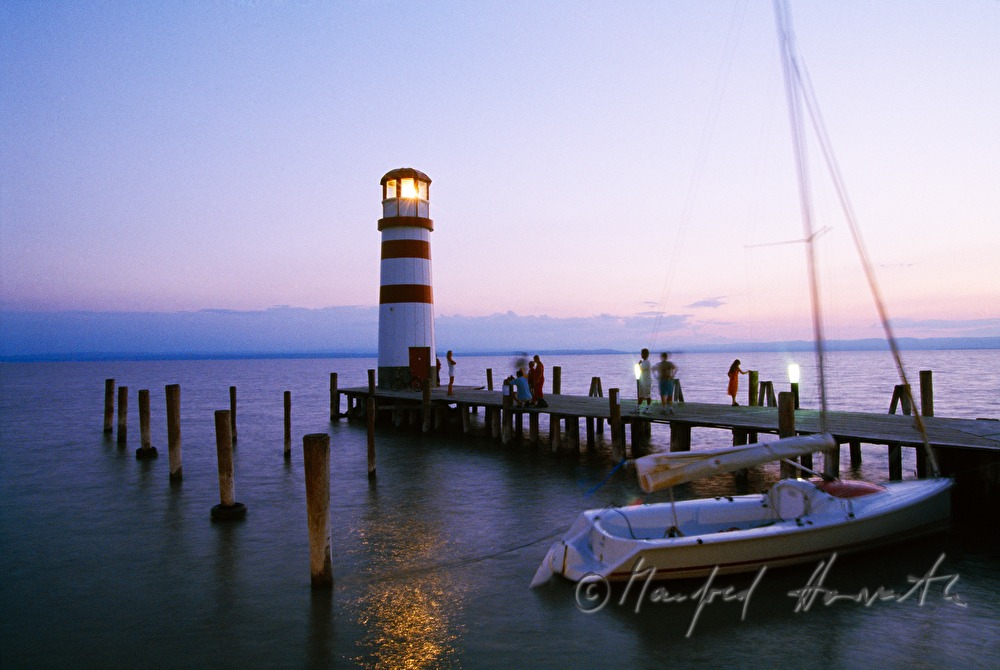 Leuchtturm, Segelboot und Steg mit Besuchern