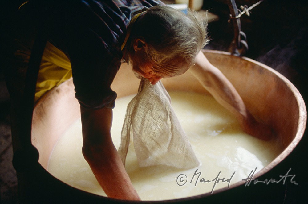 Senner sammelt geronnene Milch mit Tuch