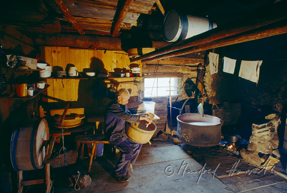 Senner kocht Milch in einem Kupferkessel