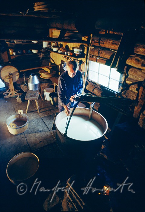 Senner kocht Milch in einem Kupferkessel