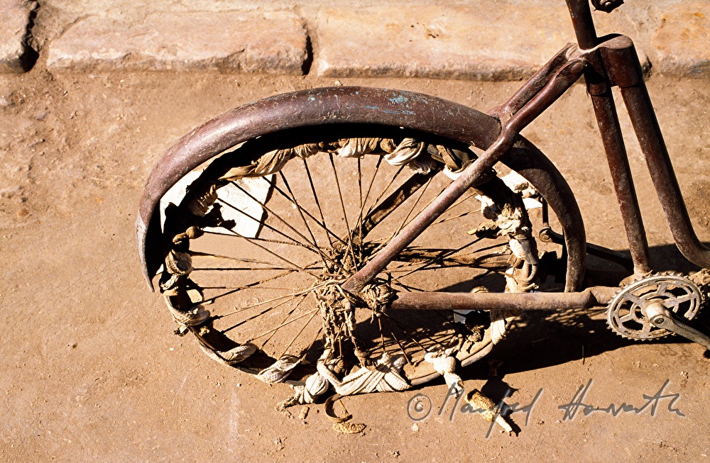 sehr altes Fahrrad mit geflicktem Rad