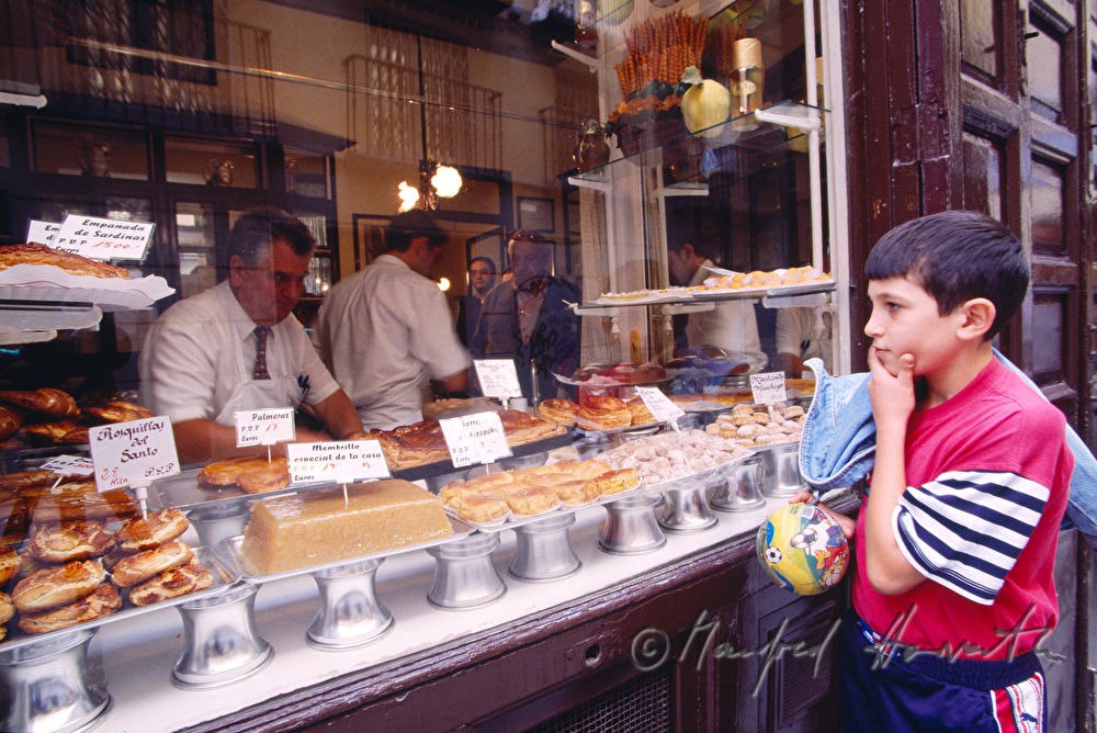 Konditor mit Mehlspeisen und fussballspielende Buben