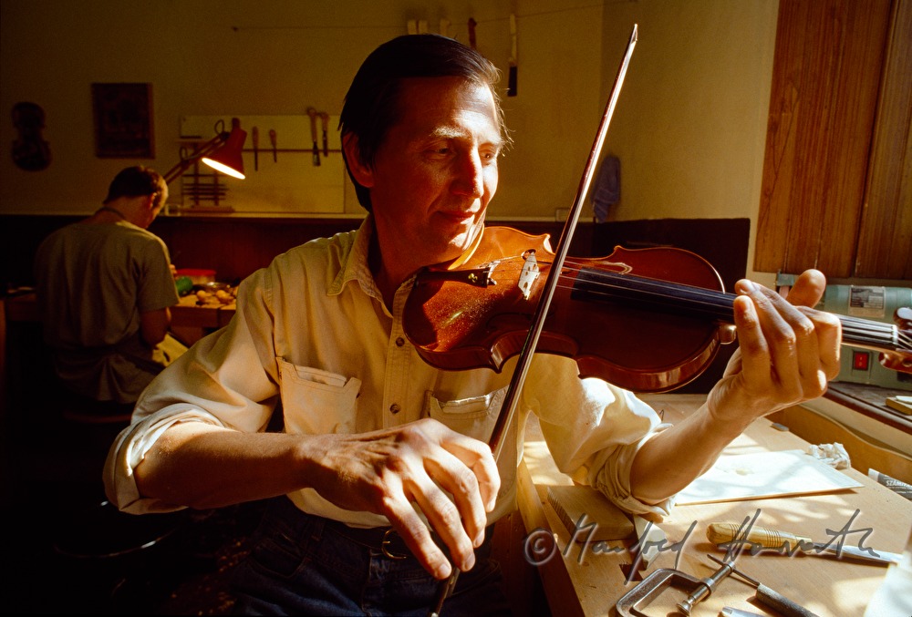 Geigenbaumeister Krillov spielt beim Arbeitstisch