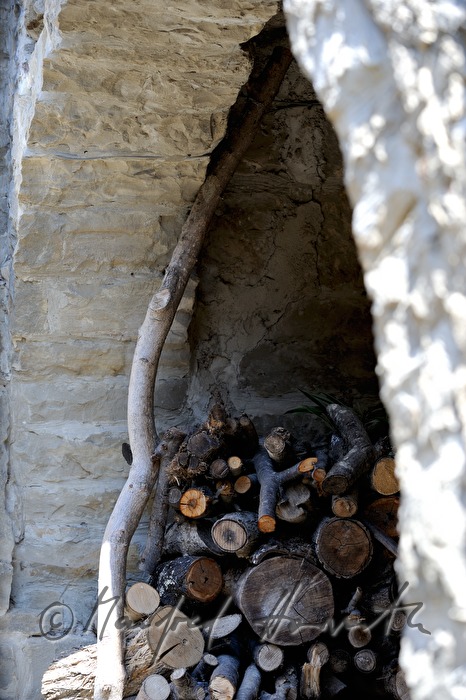 gestapeltes Brennholz bei Hausmauer