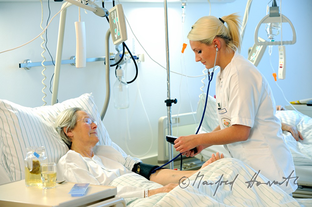 Schwester misst Blutdruck einer Patientin