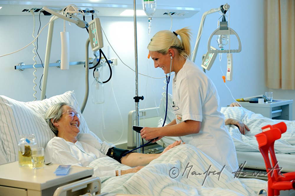 Schwester misst Blutdruck einer Patientin