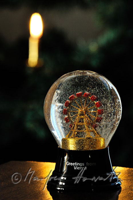 Schneekugel (mit Wiener Riesenrad) vor einem Weihnachtsbaum