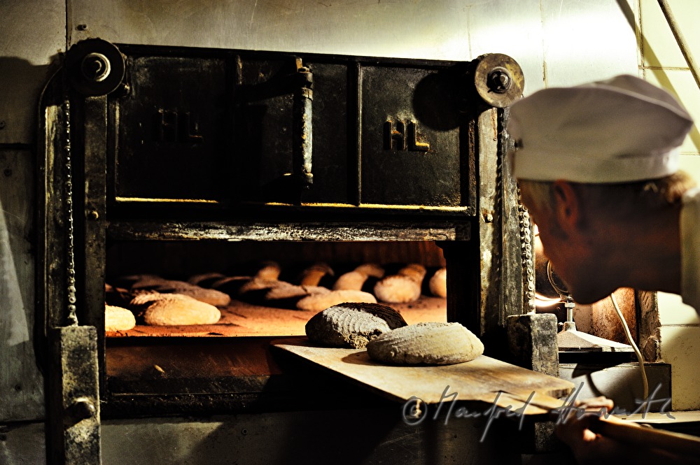 Bäcker schiesst Brot ein in den Steinofen