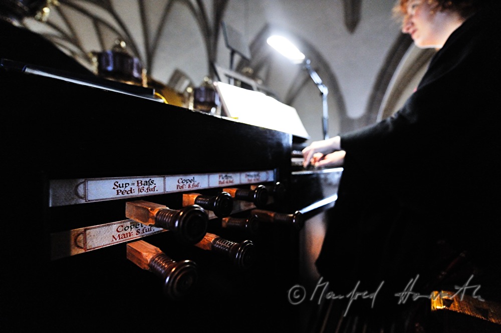 Organistin spielt die Kirchenorgel während der Messe