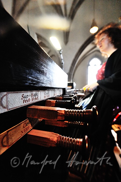 Organistin spielt die Kirchenorgel während der Messe