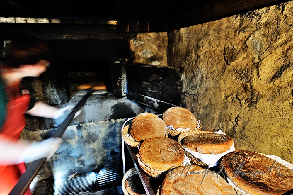 Backen von Holzofenbrot im feuerbetriebenen Backhaus