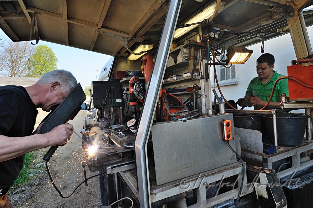 Hufschmied schweisst ein Hufeisen am mobilen Arbeitsplatz