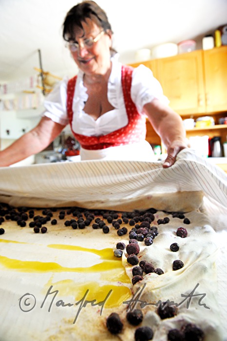 Sennerin macht Kirschenstrudel aus gezogenem Teig