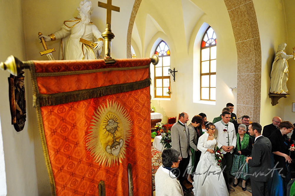Hochzeitsgesellschaft und Brautpaar beim Altar nach der  Zeremonie