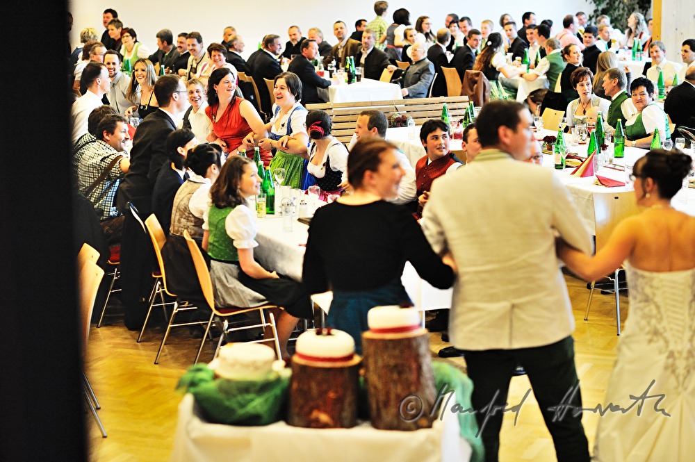 Hochzeitspaar und Hochzeitsgäste schunkeln zur Volksmusik