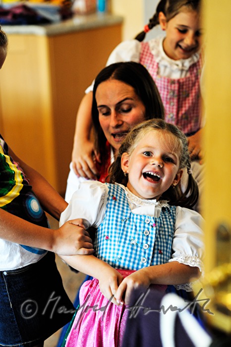 Mutter zieht der Tochter das Sonntagsdirndl an