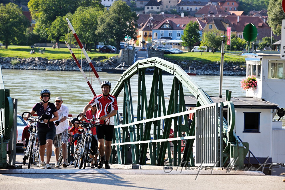 Radfahrer steigen aus Rollfähre Weissenkirchen - Rossatzbach