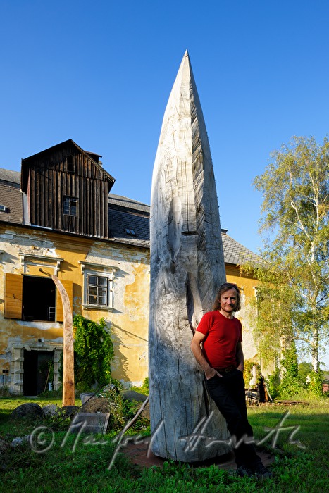 Johann Feilacher mit Baum-Skulptur vor dem Atelier