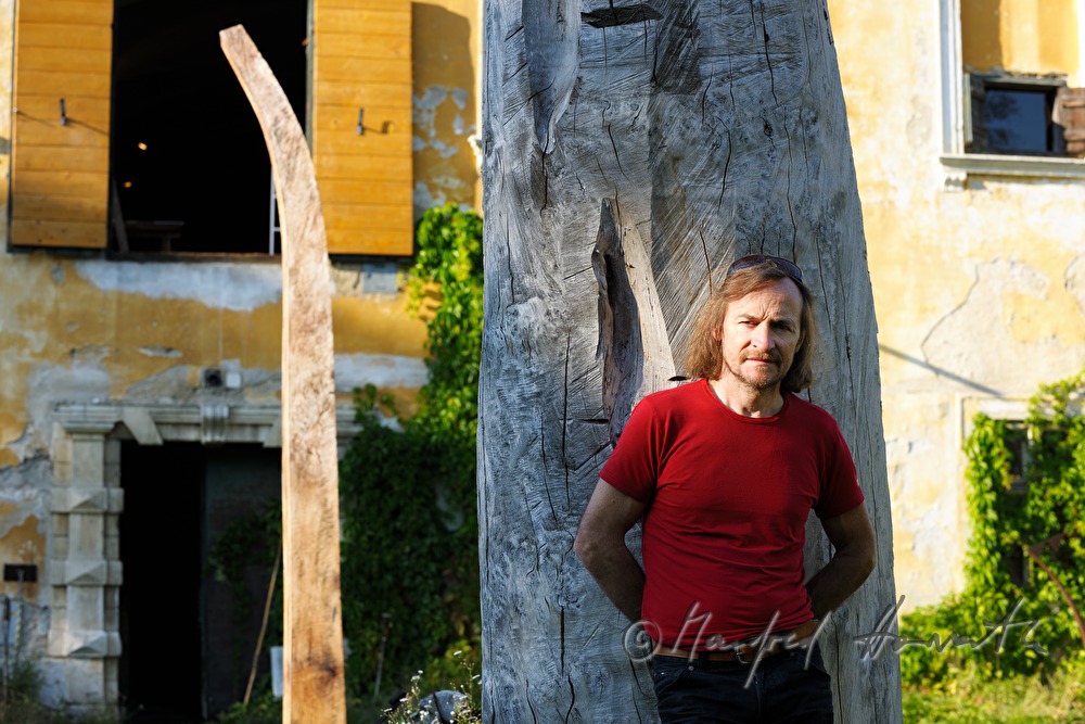 Johann Feilacher mit Baum-Skulptur vor dem Atelier