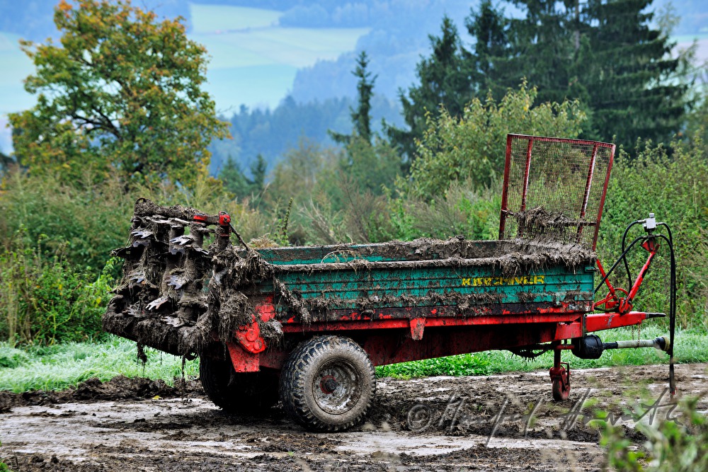 dreckiger Traktor-Anhänger auf dem Feld