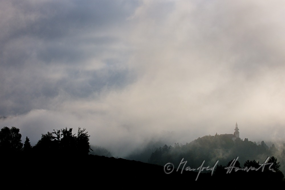Schloss Weinberg auf dem Hügel im Morgennebel