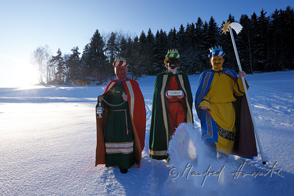Sternsinger überqueren eine Waldlichtung