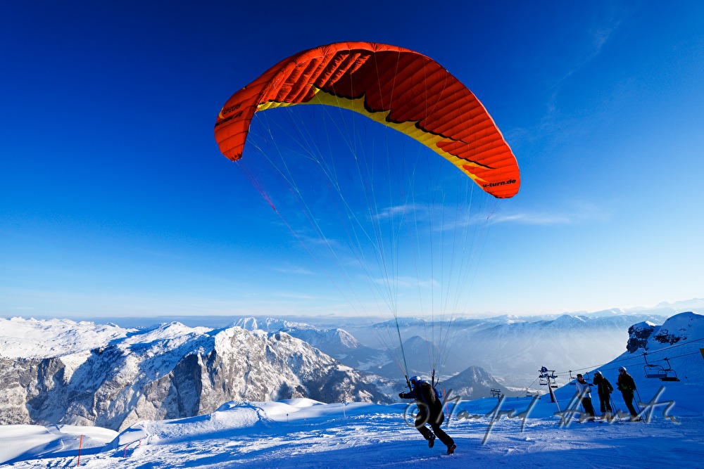 Gleitschirmflieger läuft zum Starten über die Klippe