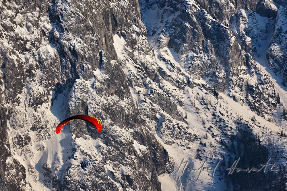 Gleitschirmflieger beim Flug in das Tal