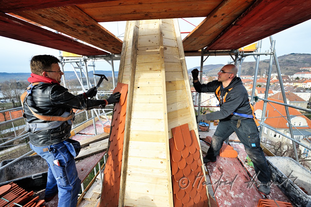 Dachdecker decken den Kirchturm ein
