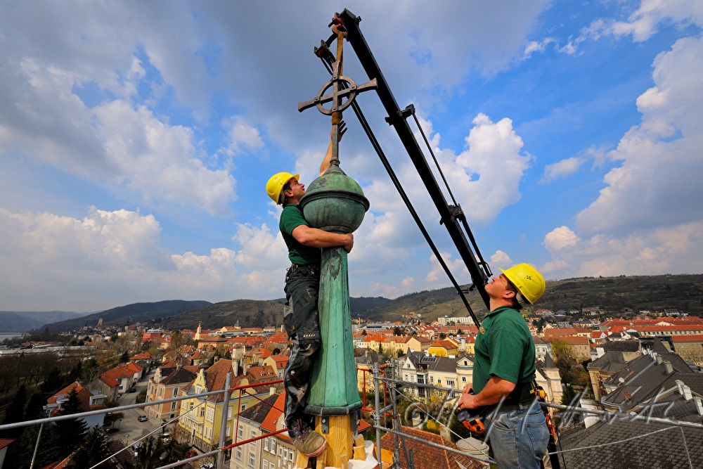 Spengler setzen den Spitz auf den Kirchturm