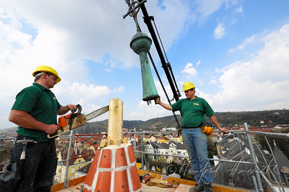Spengler setzen den Spitz auf den Kirchturm