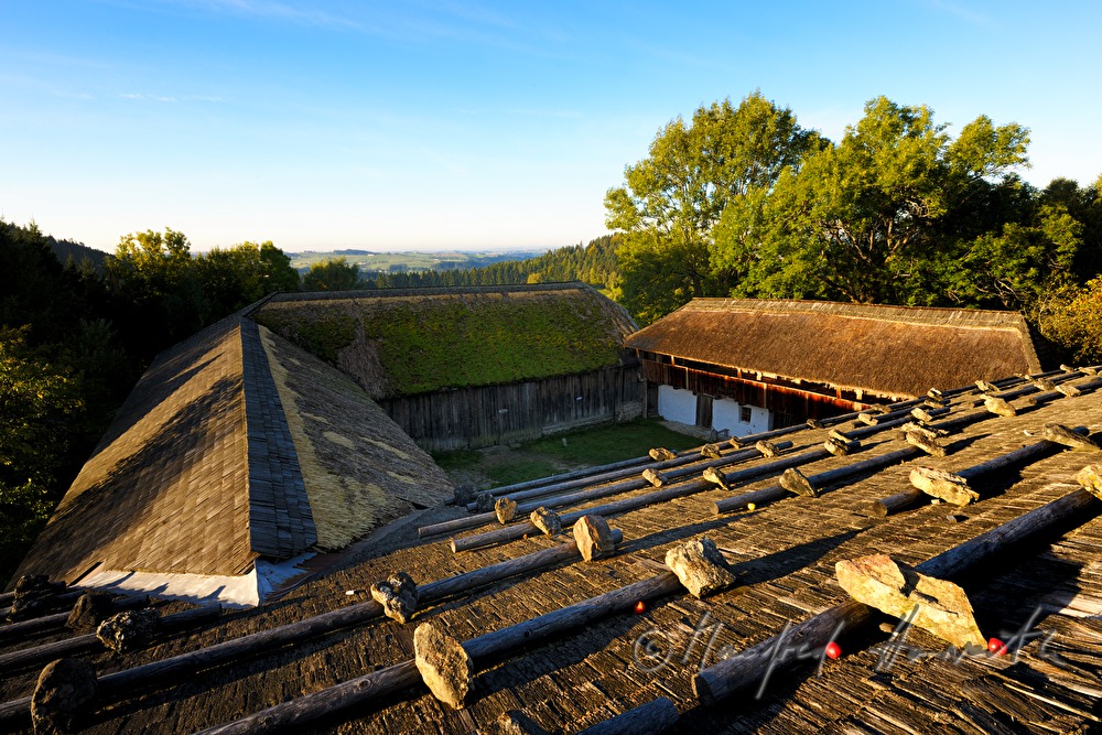 Bauernhaus mit Strohdach und Steinen auf dem Schindeldach