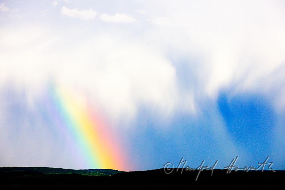 Gewitterwolken und Regenbogen