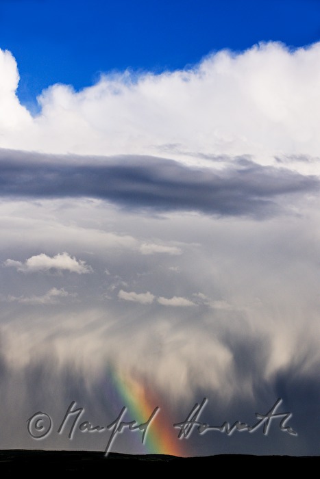 Gewitterwolken und Regenbogen