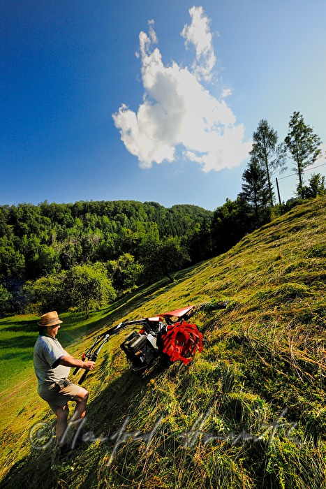 Bergbauer mäht die Wiese mit dem Motormäher
