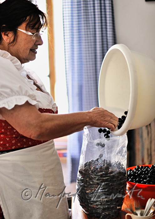 Sennerin mit Kirschen in der Küche der Alm