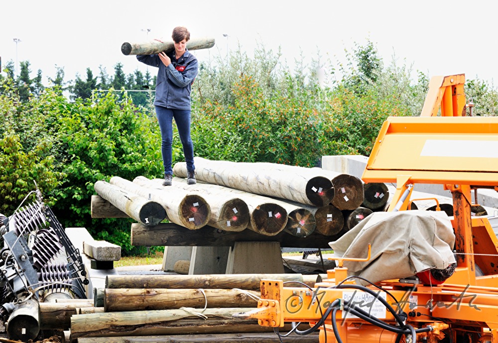 Elektromonteurin beim Verladen eines Strommastes