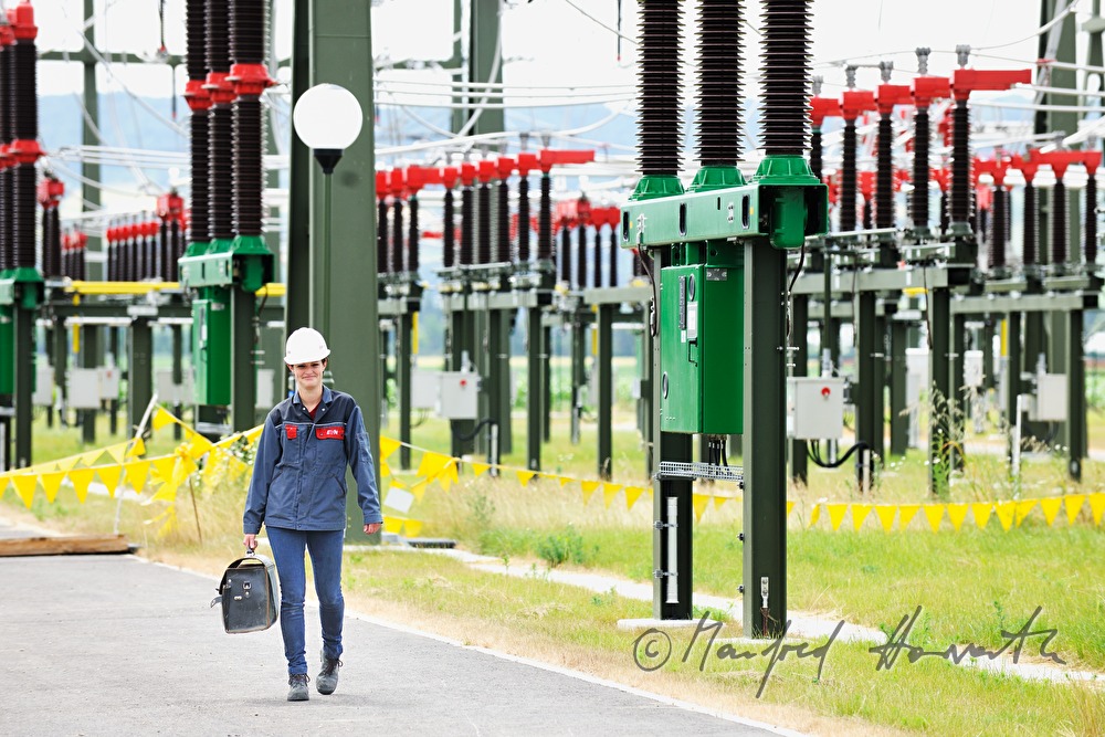 Elektromonteurin mit Werkzeugkoffer auf dem Weg zur Arbeit