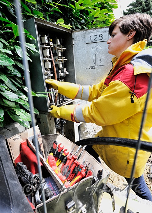 Elektromonteurin installiert einen Strom-Schaltkasten