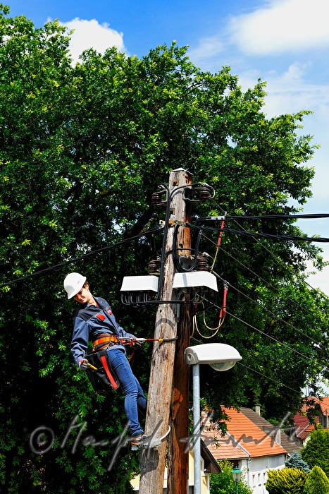 Elektromonteurin klettert auf einen Strommast