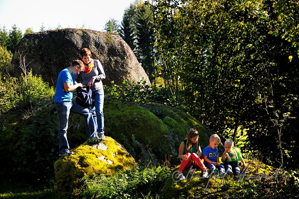 Familie macht eine Pause beim Granitblock