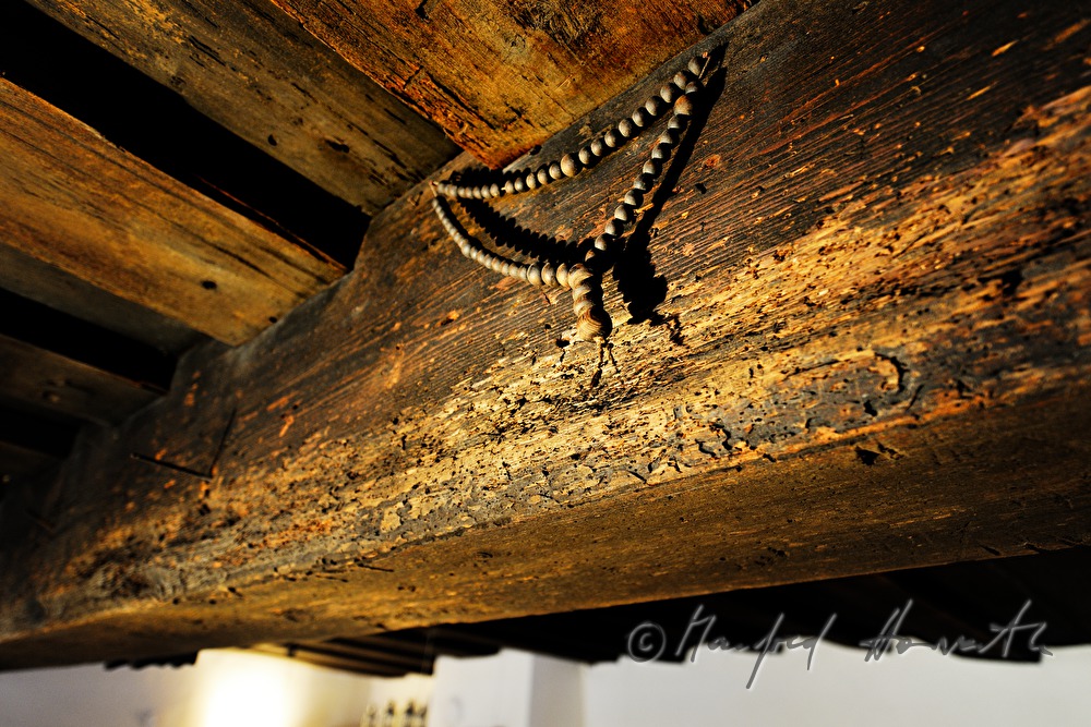 alter Rosenkranz an einem Holzbalken der Decke im Wohnzimmer