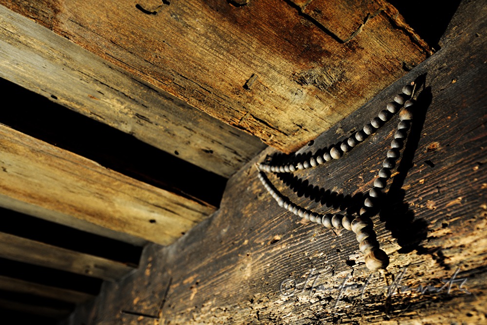 alter Rosenkranz an einem Holzbalken der Decke im Wohnzimmer