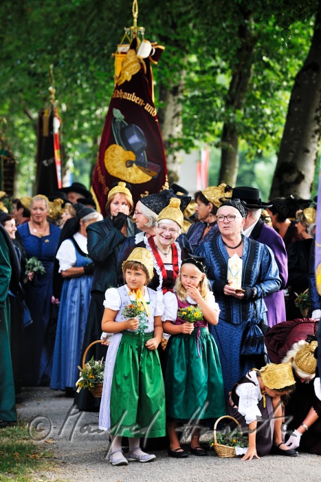 Goldhauben-Mädchen mit Kräutern für die Weihe beim Kirchgang