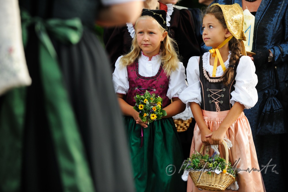 Goldhauben-Mädchen mit Kräutern für die Weihe beim Kirchgang