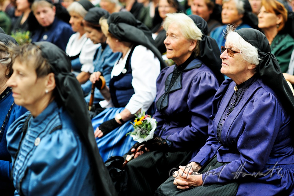 Besucher der Messe in traditioneller Tracht